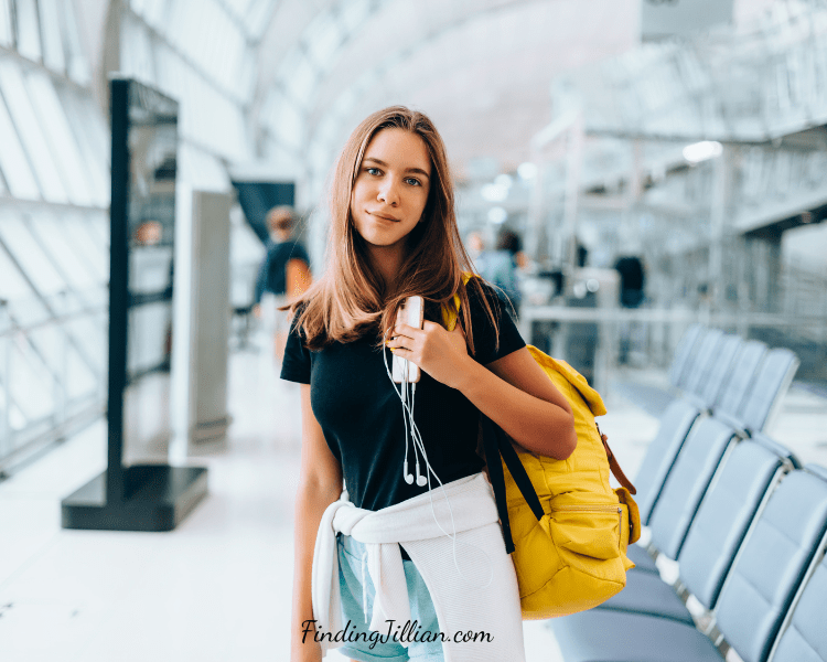 image of young women with backpack and phone - what to pack for a teen carryon